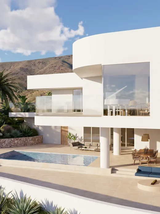 Aerial view of Draguito villa's curved white volume, pool, and terrace against a volcanic hillside in Fuerteventura.
