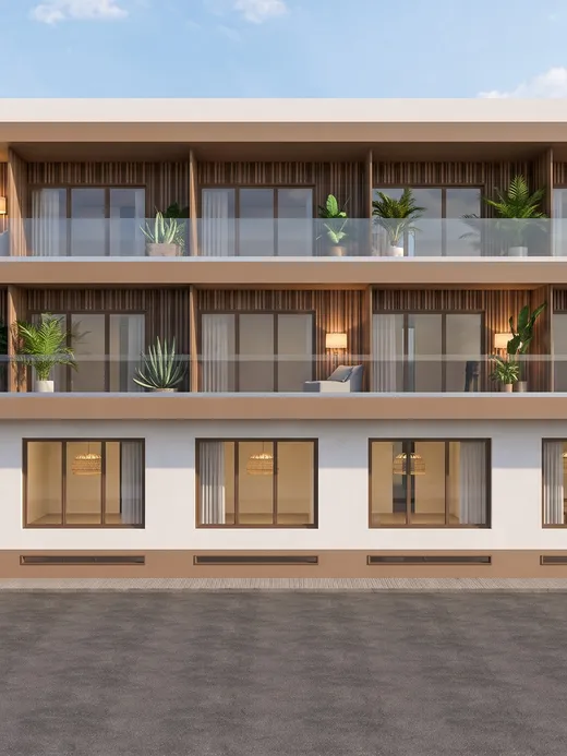 Angled daytime view of the Thalassa Living building showing its glass-railed balconies, ground-floor parking entrance, and the Thalassa Living signage.