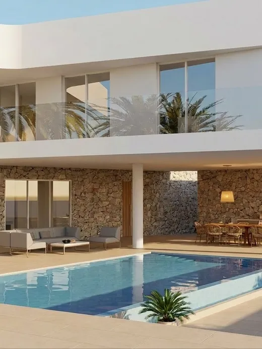 Infinity-edge pool and covered terrace of Draguito villa with stone-clad walls and mountain views.