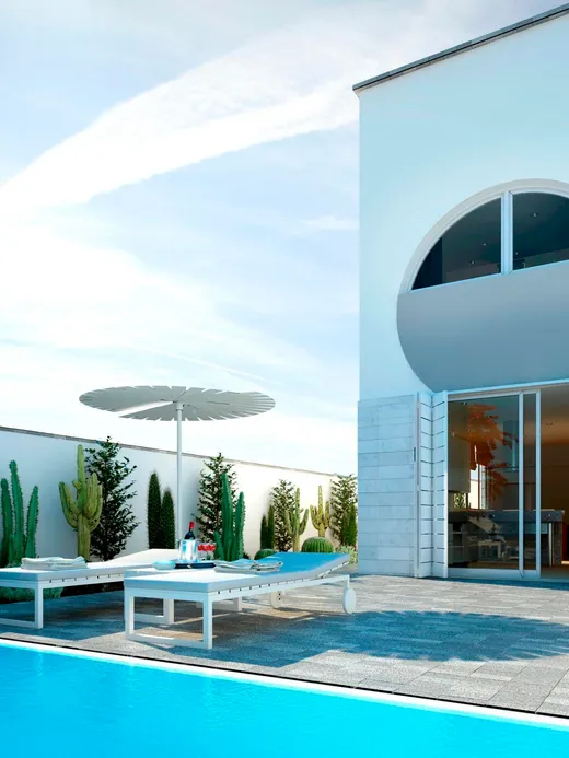 White villa with a circular porthole window and a half-round balcony recess, beside a lap pool and a garden of cacti and palms.