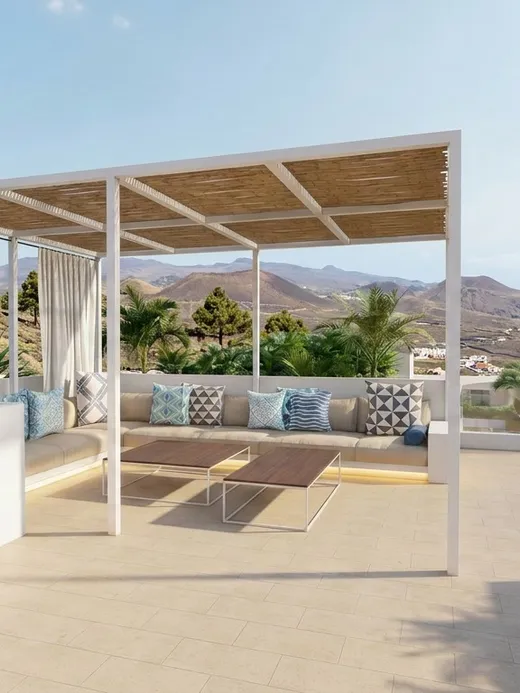 Rooftop terrace with a timber pergola, curtained lounge seating, and panoramic views over the coastline and ocean.