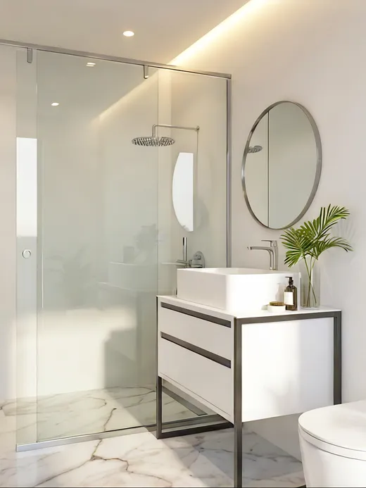 En-suite bathroom with a frameless glass shower, a round wall mirror, a floating white vanity, and potted greenery.