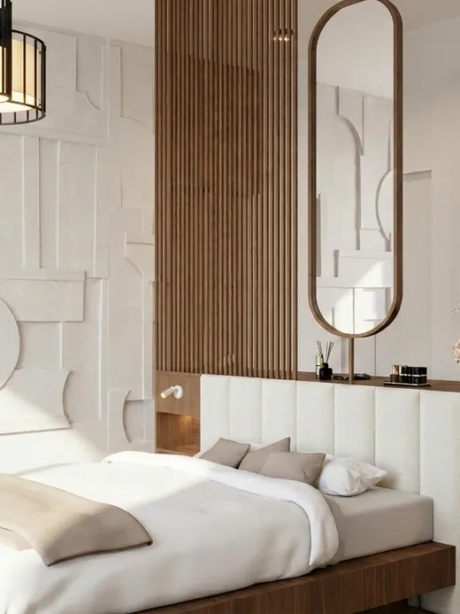 Primary bedroom with a sculpted plaster feature wall, a floating oak vanity, an oval mirror, and pendant lighting over the bed.