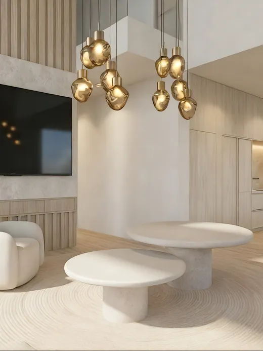 Dining area with a walnut table and upholstered chairs beneath a brass leaf-shaped pendant light, framed by abstract artwork and the kitchen beyond.