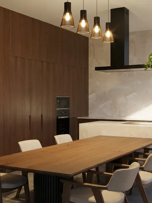 Open kitchen and dining area with dark walnut cabinetry, a stone-topped island, pendant lighting, and a long walnut dining table.