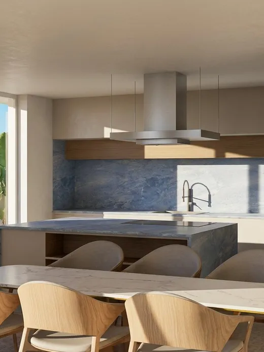 Kitchen at Draguito villa with a stone-clad island, dark blue backsplash, and adjoining dining table.