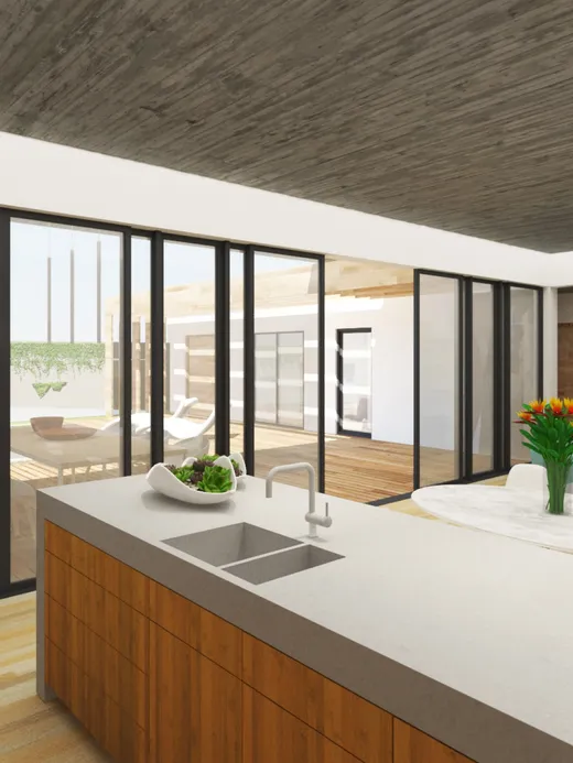 Kitchen with a timber island and a concrete ceiling, its glazed walls opening to the pool terrace.